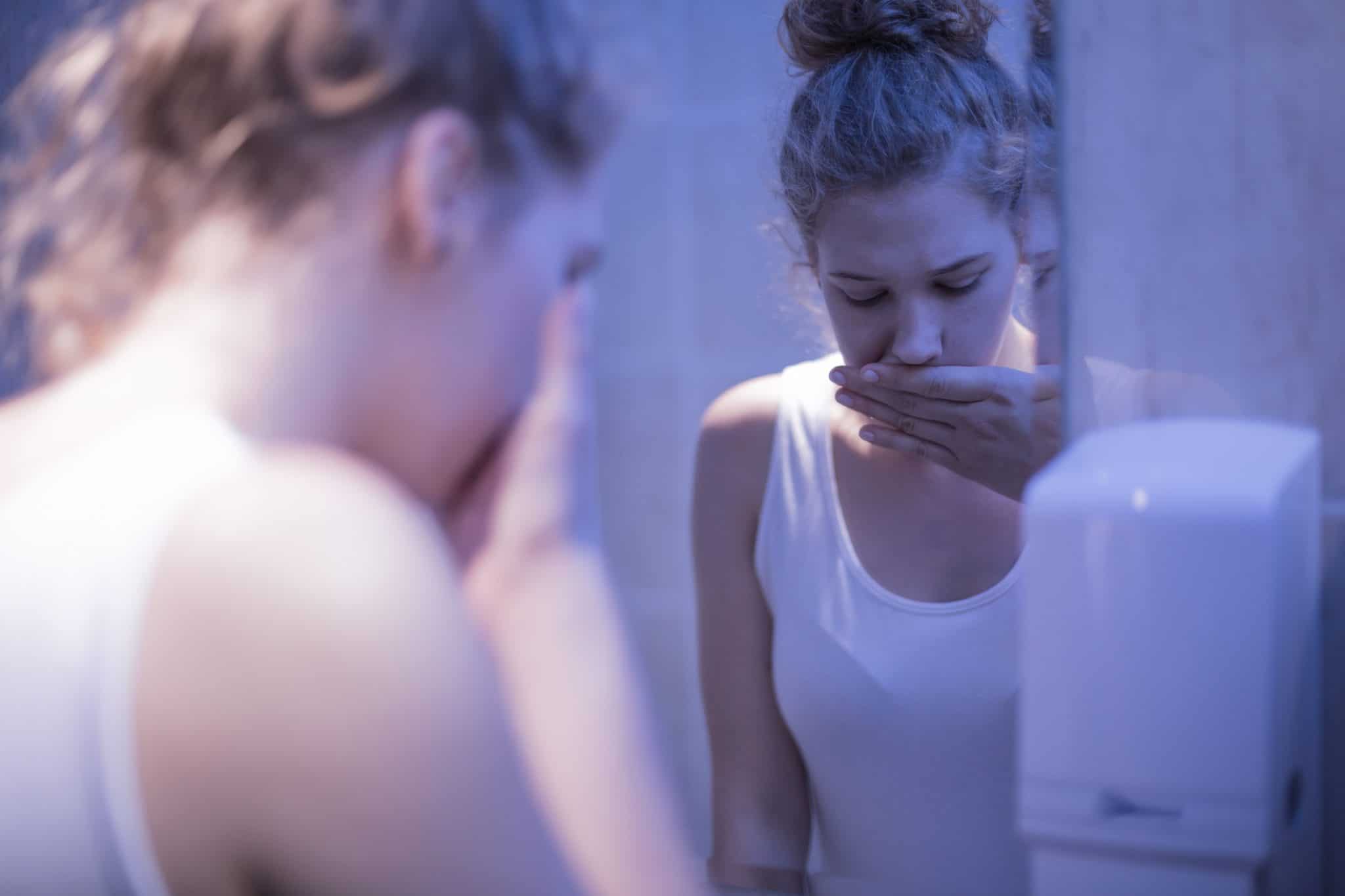 Worried girl standing in front of mirror