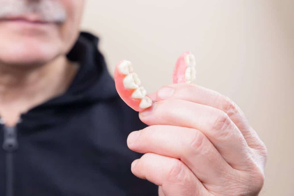 man holding his denture