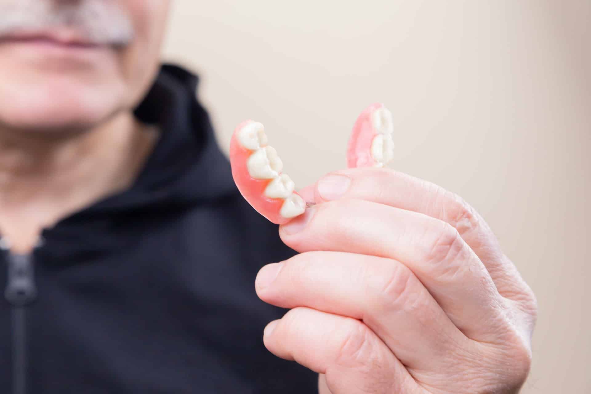 man holding his denture