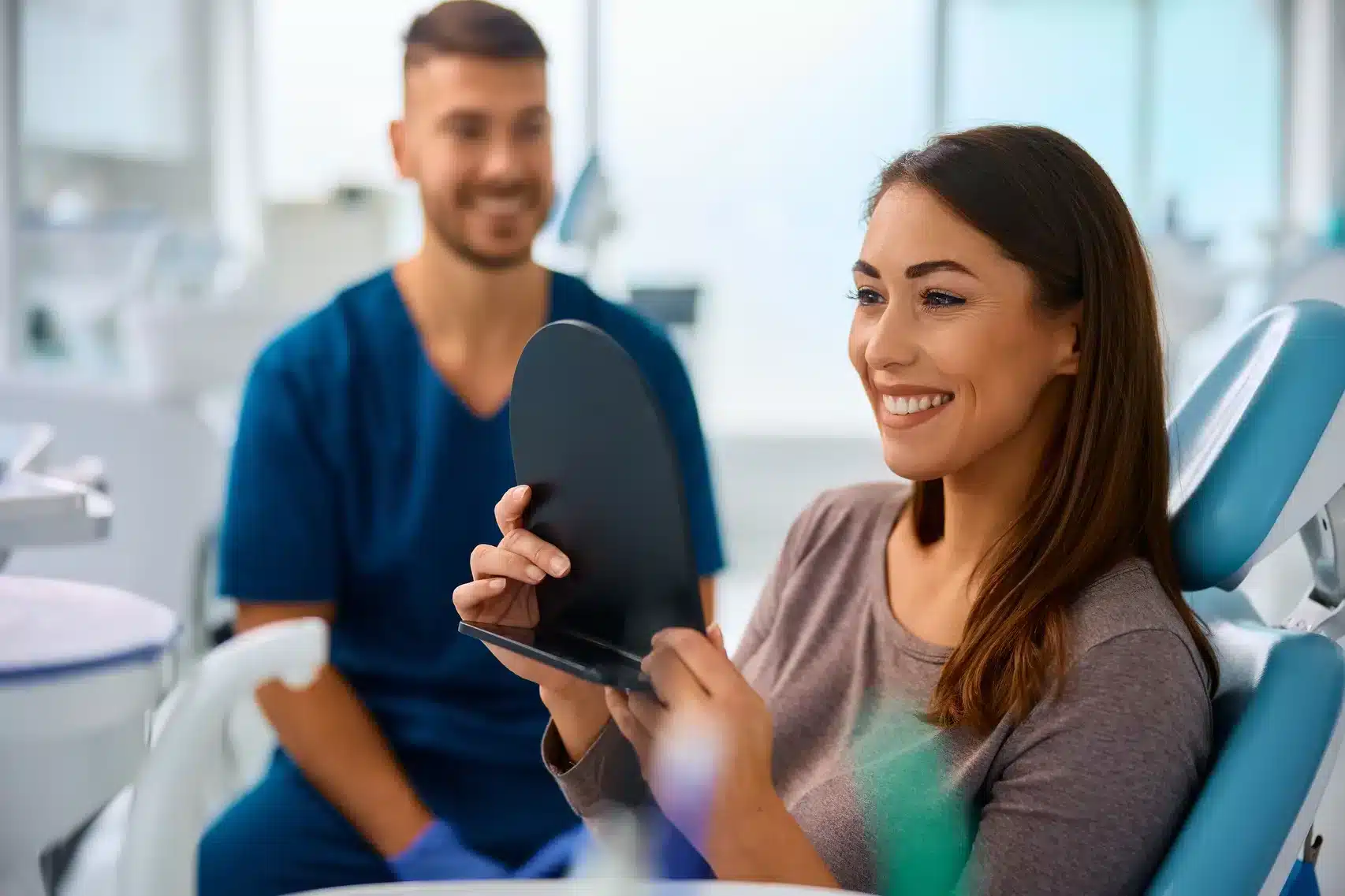 Patient viewing her smile after dental care