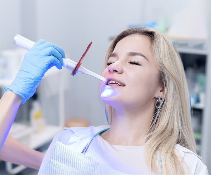 Dentist using a curing light during treatment