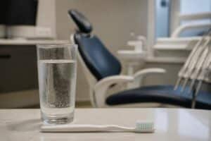 Cold glass of water and toothbrush in a dental treatment room
