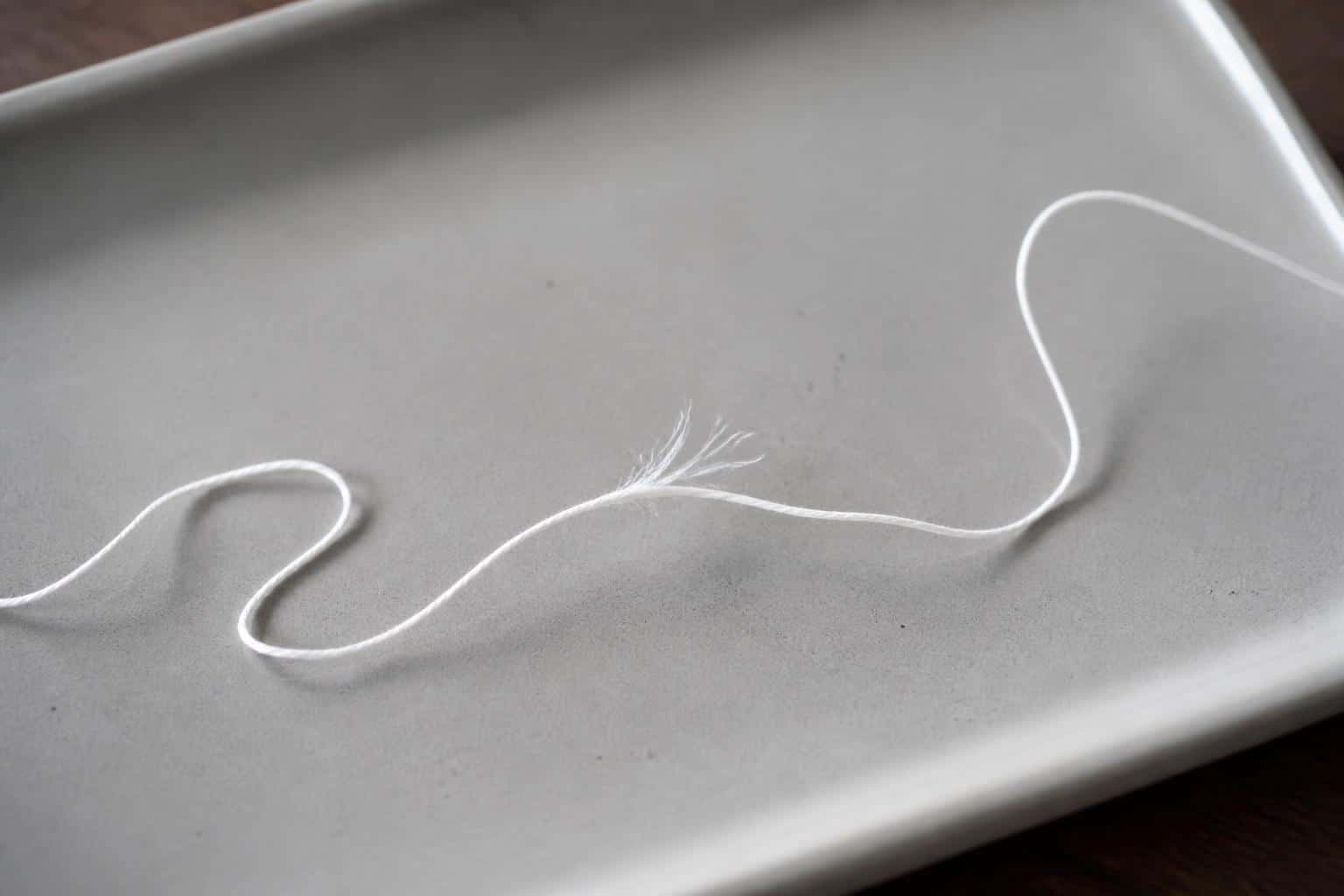 Frayed section of dental floss resting on a clean tray