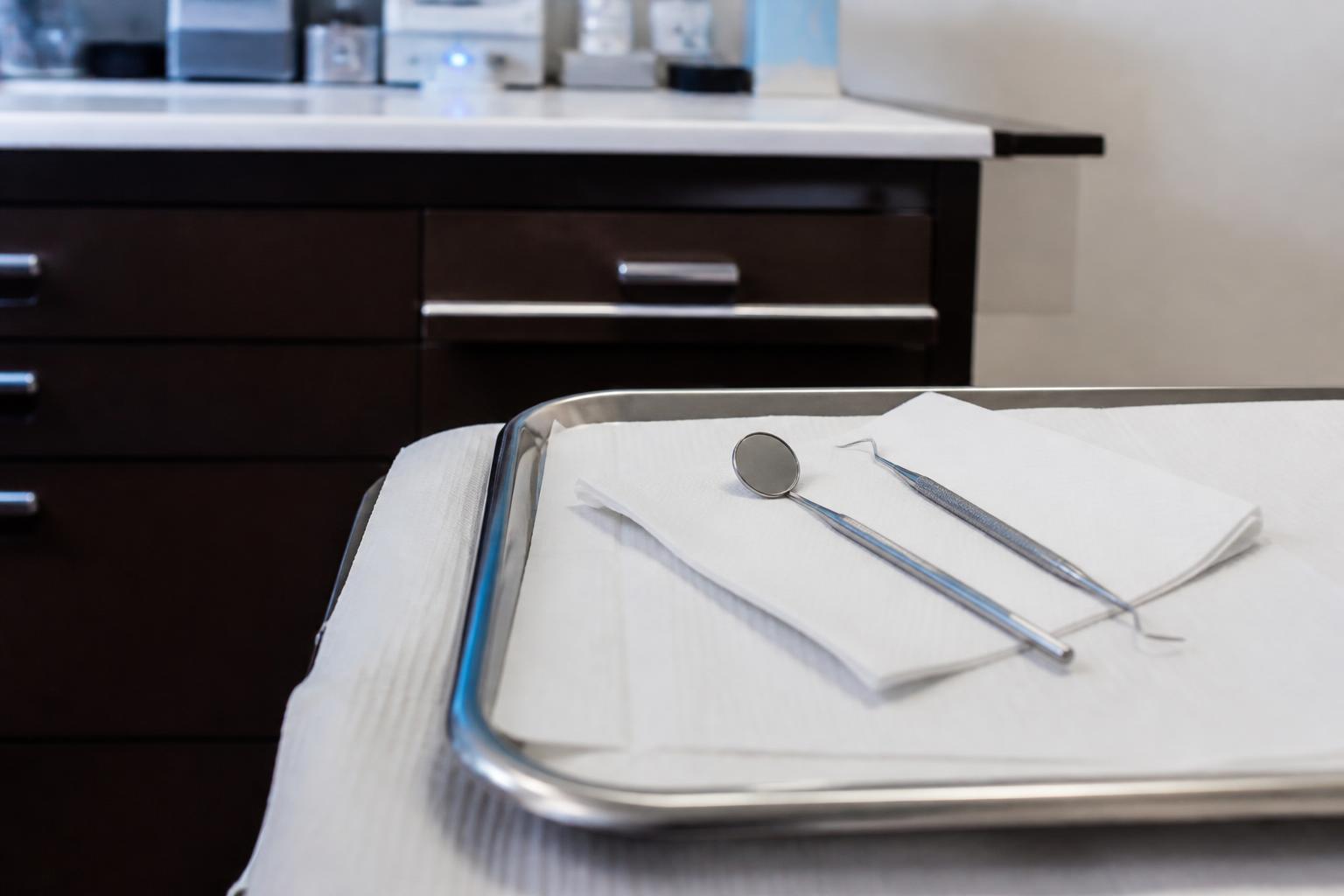 Clean dental tray with a mouth mirror and explorer instrument used during a root canal exam
